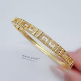 Close-up of the Greek Key Bangle showing intricate Greek pattern design with 18K gold plating and Cubic Zirconia sparkle, emphasizing the texture and fine craftsmanship.
