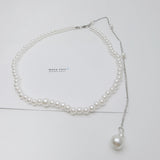 Close-up of the Gracefall Pearl Necklace showing a strand of radiant imitation pearls cascading from a gold-toned copper chain. The rich luster and bold design offer a luxurious, high-impact look perfect for dressing up any outfit.