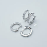 a pair of mini huggies hoops earrings set with little diamonds. 