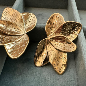 Close-up view of the Baroque Gold Studs showcasing their intricate sculptural design and glossy 14K gold plating. The textured, uneven surface mimics classic baroque patterns, giving a luxurious and bold statement look. Stainless steel base visible in fine detail.