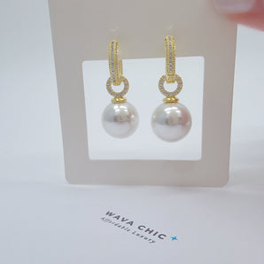 Detailed view of Everly Pearl Dangling Hoops with gold-plated titanium hoops and artificial pearl drops, showing smooth shine and quality craftsmanship.