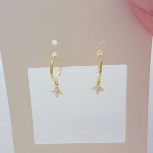 Close-up of the Blossom Shine Hoop Earrings featuring delicate floral clusters of cubic zirconia set in 925 sterling silver. Available in both gold and silver finishes, these hoops reflect light beautifully with each tiny stone catching a soft sparkle for a radiant yet refined look.