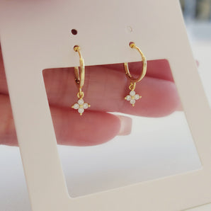 Close-up of the Blossom Shine Hoop Earrings featuring delicate floral clusters of cubic zirconia set in 925 sterling silver. Available in both gold and silver finishes, these hoops reflect light beautifully with each tiny stone catching a soft sparkle for a radiant yet refined look.