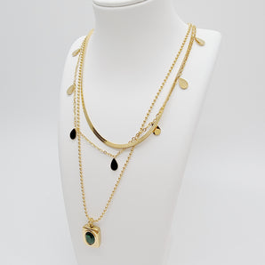 Close-up of the Triple Layers Emerald Necklace featuring three gold electroplated chains with emerald-colored charm detailing. Each layer offers a distinct look while maintaining an elegant and cohesive design.

