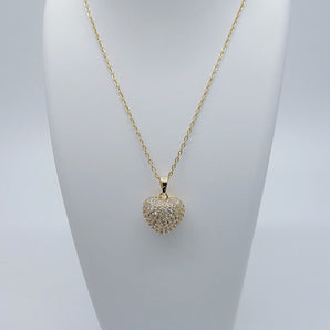 Close-up of the Apple Heart Necklace showing a heart-shaped pendant designed like an apple, paved with sparkling cubic zirconia stones. The pendant has a smooth 18K gold-plated finish, and it hangs from a sleek stainless steel chain. Crafted for durability and glamour.