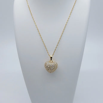 Close-up of the Apple Heart Necklace showing a heart-shaped pendant designed like an apple, paved with sparkling cubic zirconia stones. The pendant has a smooth 18K gold-plated finish, and it hangs from a sleek stainless steel chain. Crafted for durability and glamour.