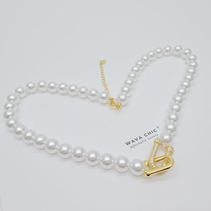Close-up of the Regalia Pearl Necklace featuring lustrous imitation pearls and a dazzling pavé cubic zirconia clasp plated in 18K gold. The detailed shot highlights the elegant clasp design and the smooth pearl finish, offering a clear view of the premium craftsmanship and luxurious texture of this Wava Chic piece.
